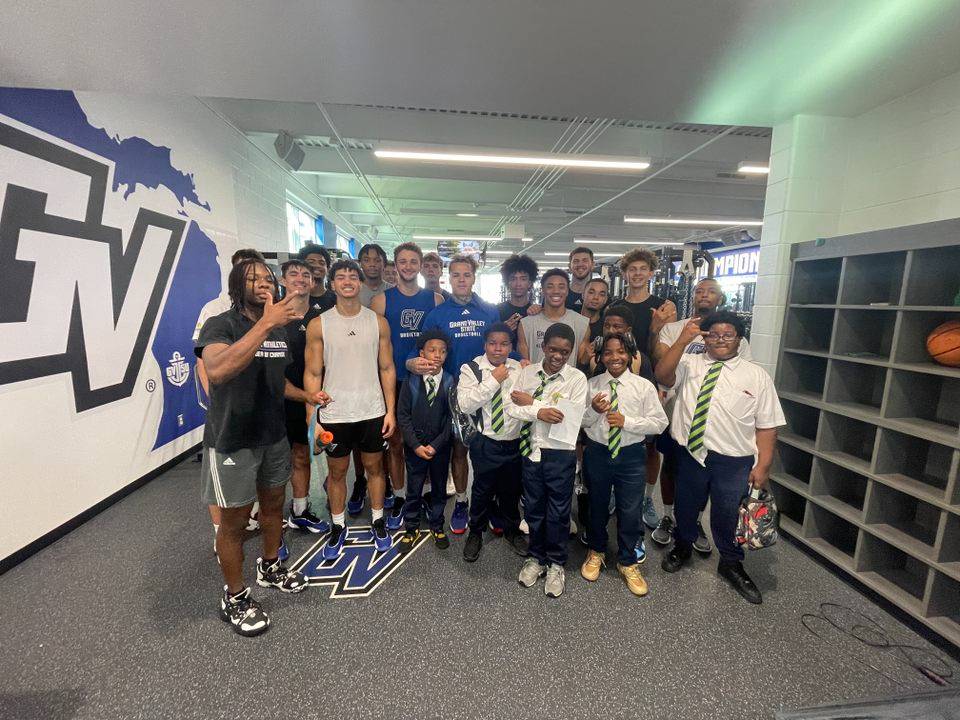 Charter School 8th Grade Students posing with the GVSU basketball team